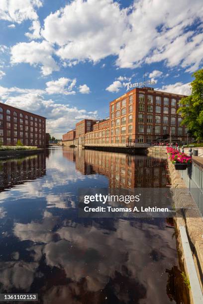 old red brick industrial buildings along the tammerkoski rapids in downtown tampere, finland on a sunny day. - tampere foto e immagini stock
