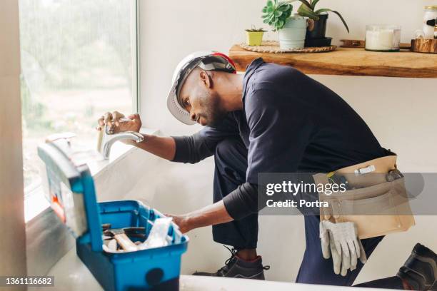 plumber fixing a leaking bathroom faucet - leaking sink stock pictures, royalty-free photos & images