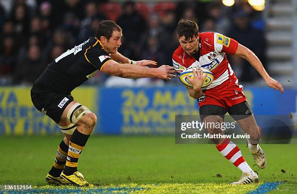 Freddie Burns of Gloucester breaks through the tackle of Richard Birkett of Wasps during the Aviva Premiership match between Gloucester and London...