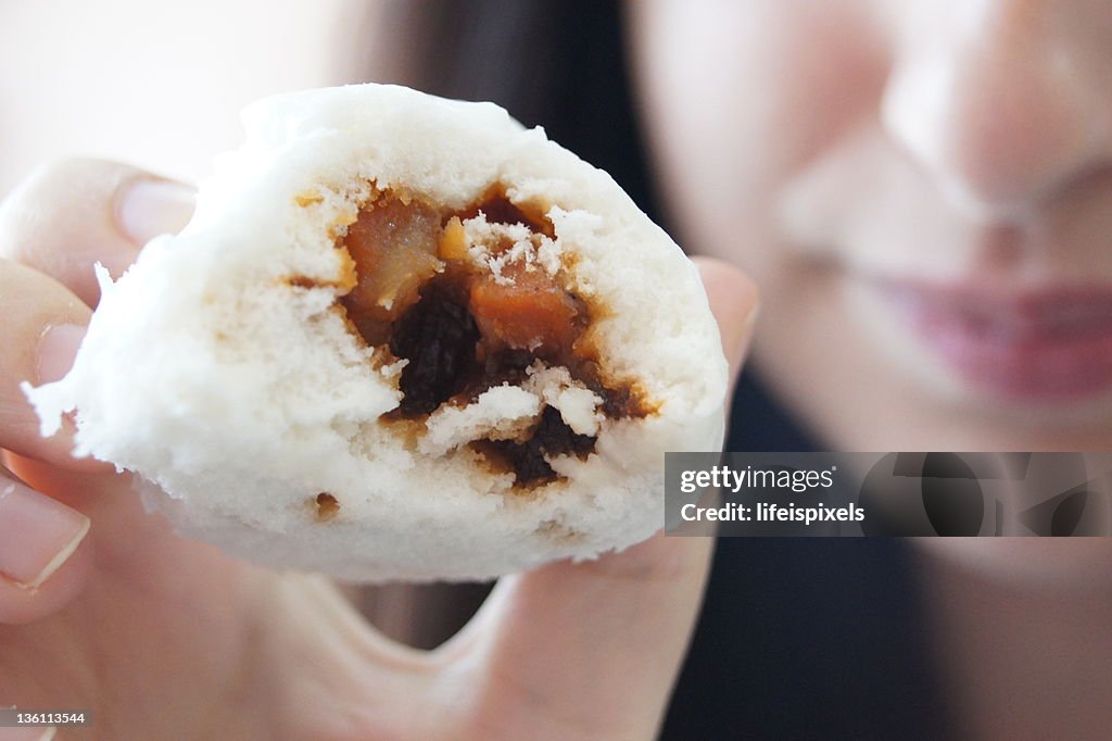 Woman showing sweet pork inside soft white bun