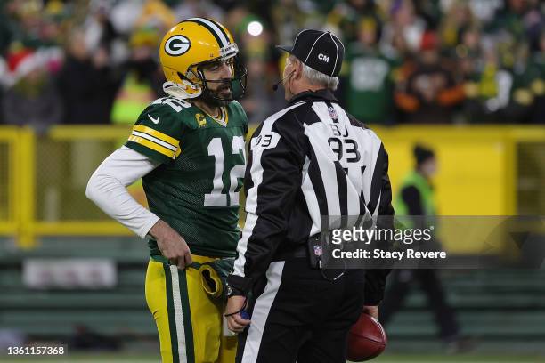 Aaron Rodgers of the Green Bay Packers speaks with back judge Scott Helverson during a game against the Cleveland Browns at Lambeau Field on December...