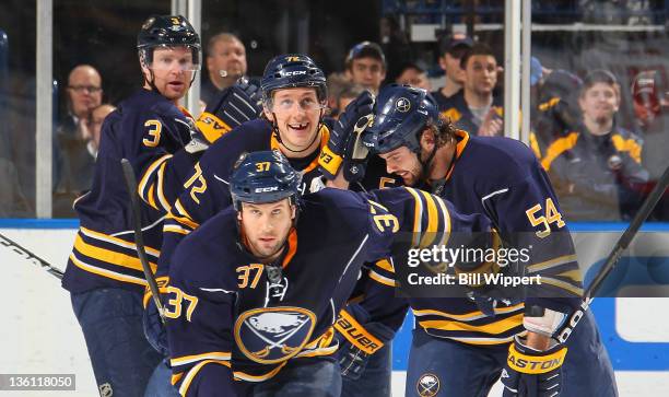 Matt Ellis of the Buffalo Sabres leads teammates Jordan Leopold, Luke Adam, and Zack Kassian to the bench after scoring a first period goal against...