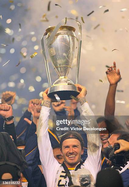 David Beckham of the Los Angeles Galaxy hoists over his head the Philip F. Anschutz Trophy after defeating the Houston Dynamo 1-0 in the 2011 MLS Cup...