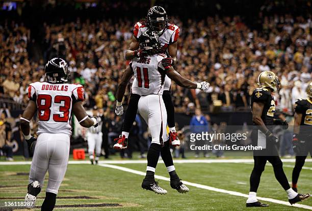 Wide receiver Julio Jones of the Atlanta Falcons celebrates his 21-yard first quarter touchdown catch with teammate wide receiver Roddy White against...