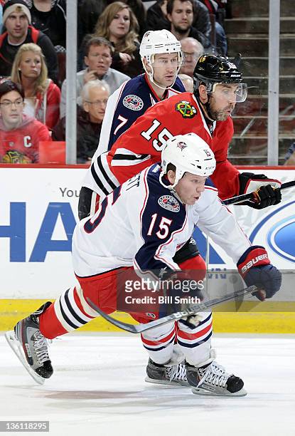 Derek Dorsett and Jeff Carter of the Columbus Blue Jackets, and Andrew Brunette of the Chicago Blackhawks skate up the ice during the NHL game on...