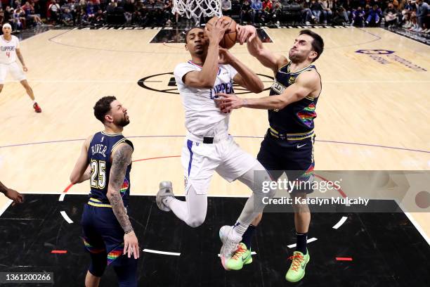 Keon Johnson of the Los Angeles Clippers drives to the basket against Facundo Campazzo and Austin Rivers of the Denver Nuggets during the fourth...