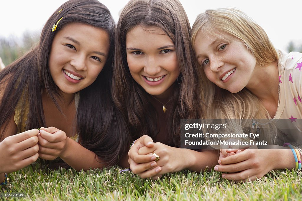 Teenage girls (13-14) in garden, portrait, smiling