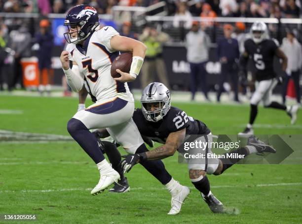 Defensive back Keisean Nixon of the Las Vegas Raiders tackles quarterback Drew Lock of the Denver Broncos shy of a first down on a third-down play in...