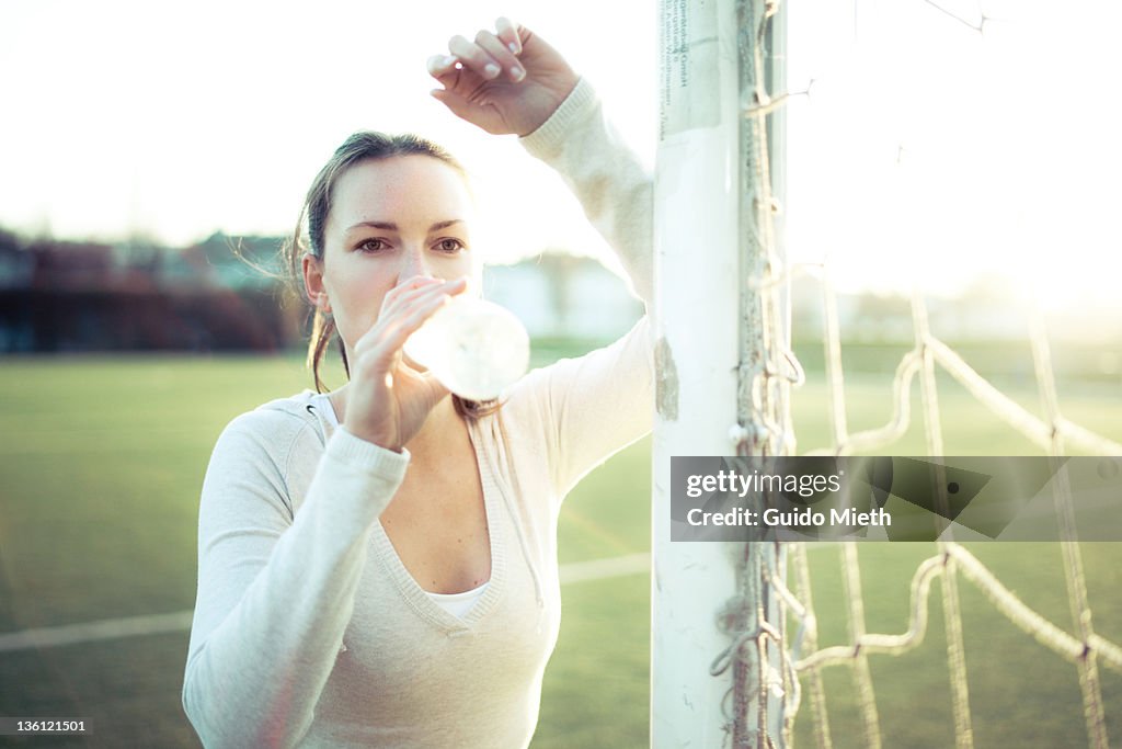 Women drinking water on sports field