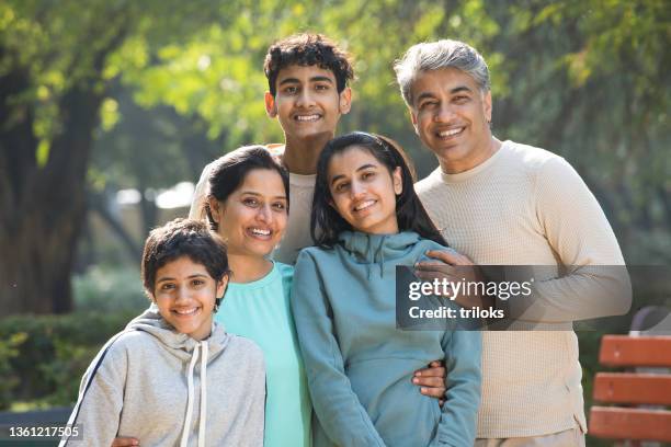 retrato de una familia feliz divirtiéndose en el parque - familia con tres hijos fotografías e imágenes de stock