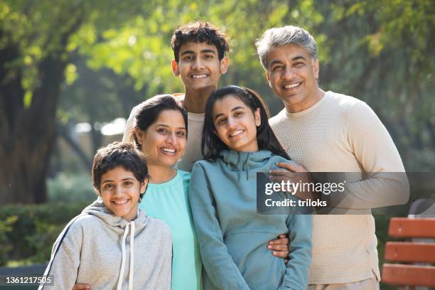 portrait of happy family having fun at park - indian family in their 40's with kids imagens e fotografias de stock