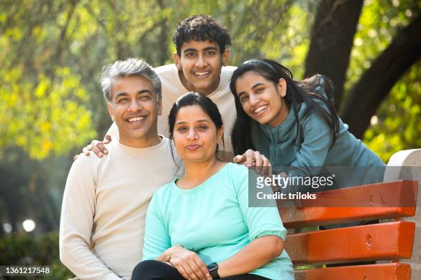 portrait of happy family at park - image stock pictures, royalty-free photos & images