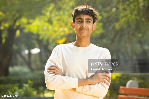 portrait of happy teenage boy at park - teen indian boy stock pictures, royalty-free photos & images