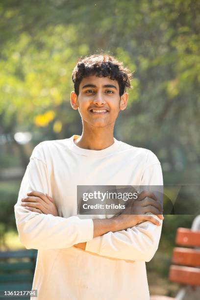 portrait of happy teenage boy at park - indian boy portrait stockfoto's en -beelden