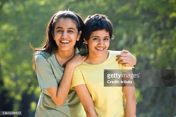 portrait of teenage sibling having fun at park - brother and sister stockfoto's en -beelden