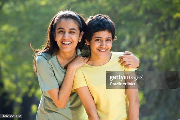 portrait of teenage sibling having fun at park - sister day stock pictures, royalty-free photos & images