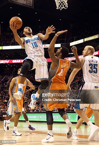 Eric Gordon of the New Orleans Hornets puts up a shot past Markieff Morris of the Phoenix Suns during the season openning NBA game at US Airways...