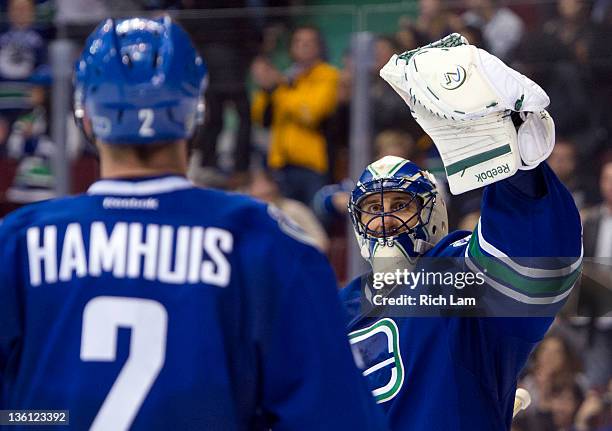 Goalie Roberto Luongo of the Vancouver Canucks celebrates with teammate Dan Hamhuis after defeating the Edmonton Oilers during the third period in...