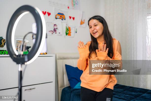 side view portrait of teenage  girl filming videos at home and dancing to camera set on ring light, young blogger concept, copy space - camera girls stockfoto's en -beelden