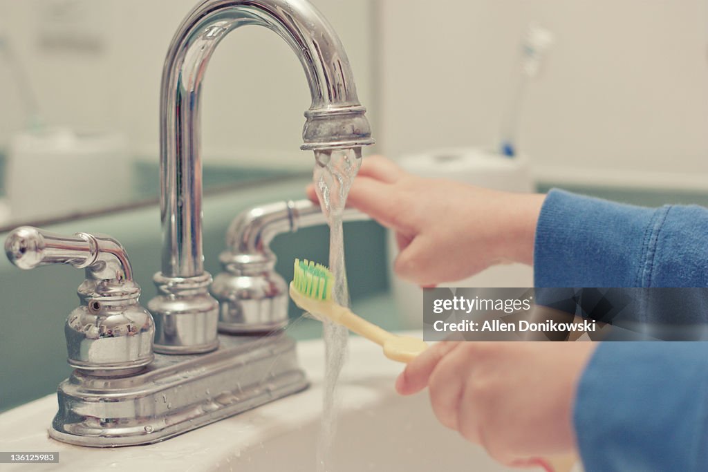 Boy washing his tooth brush