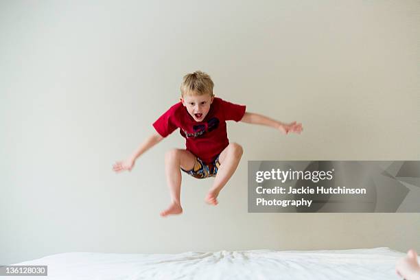 boy jumping on bed - a boy jumping on a bed stock pictures, royalty-free photos & images