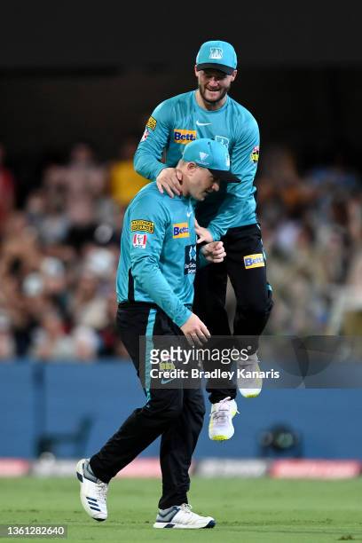 Max Bryant of the Heat celebrates with Ben Duckett after catching out Nathan Coulter-Nile of the Stars during the Men's Big Bash League match between...