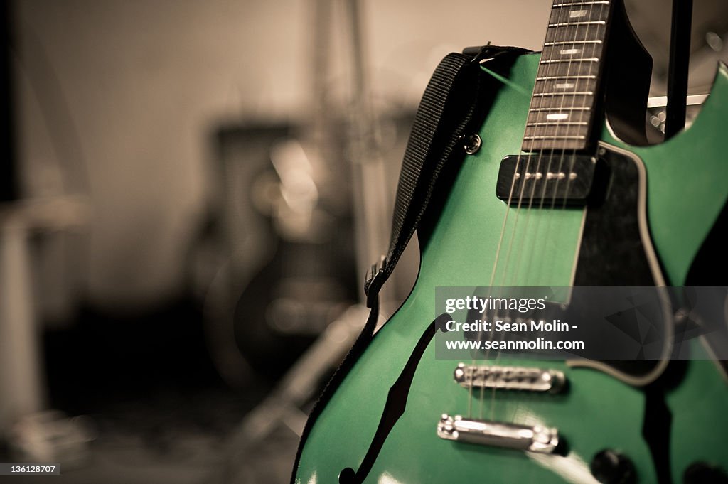 Green electric guitar with blurry background