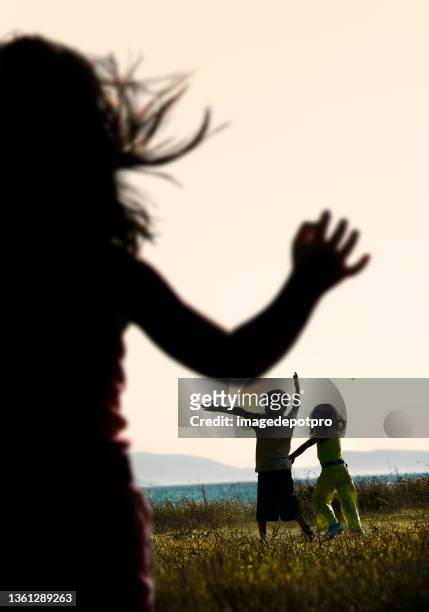 happy group of children playing in nature by seaside over sunny sky - summer super 8 stockfoto's en -beelden