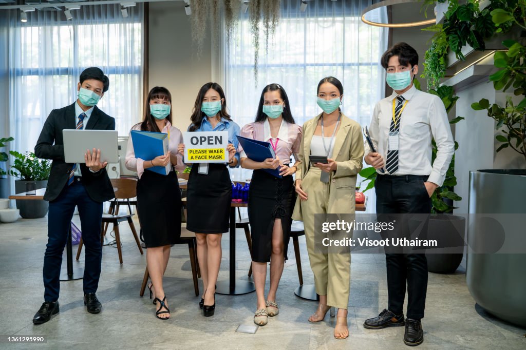 Office employee with protective face mask from Coronavirus,Support and collaboration together to overcome epidemic of Coronavirus or COVID-19 to reopen business.
