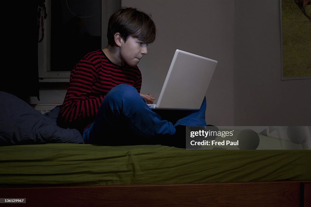 Boy using laptop in his room