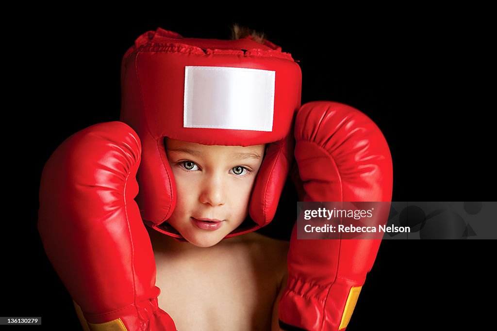 Boy wearing boxing gloves and helmet