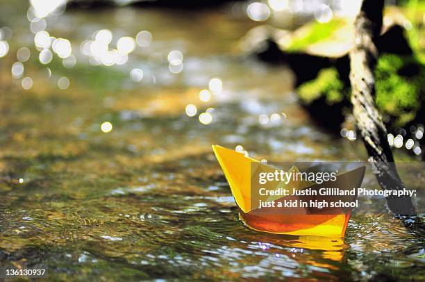 boats and bokeh in brook - paper boat stock-fotos und bilder