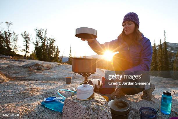 a female enjoying sunrise at her camp site. - camping stove stockfoto's en -beelden