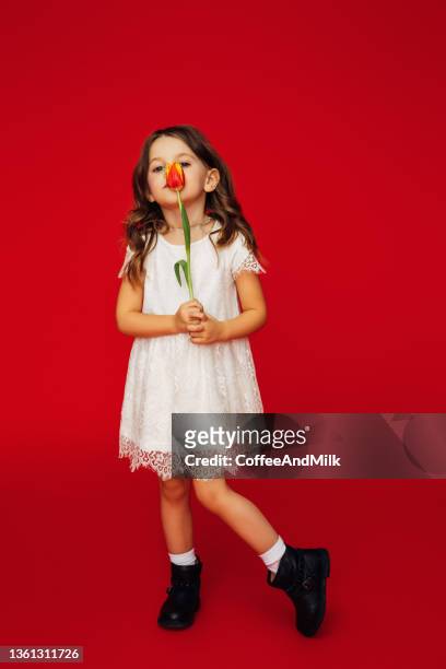 cute little girl in white dress holding a flower - sweet little models stock pictures, royalty-free photos & images