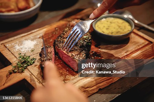 Unrecognizable Woman Eating Steak in High End Restaurant Unrecognizable Woman Eating Steak in High End Restaurant