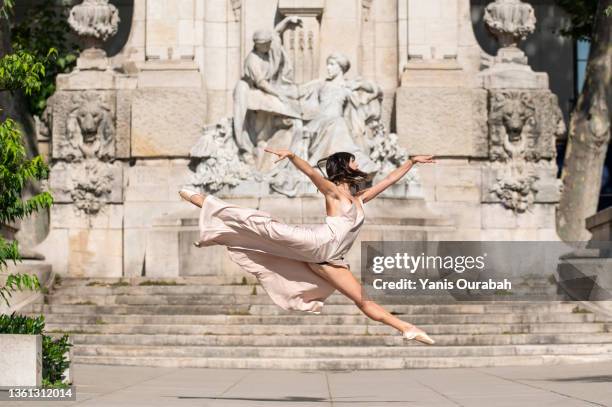 female ballet dancer dancing alone in the street wearing a dress and pointes - urban ballet stockfoto's en -beelden