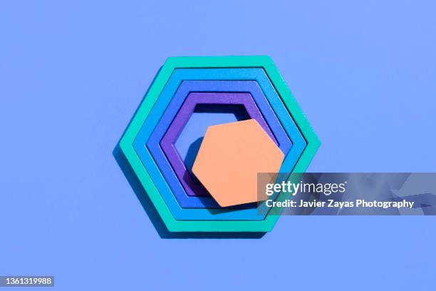 multi colored hexagons jigsaw puzzle on blue background - wrap up foto e immagini stock