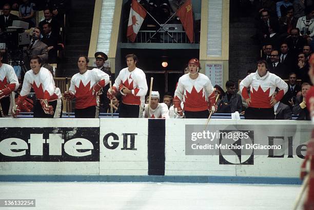 Pete Mahovlich, Dennis Hull and Jean Ratelle, Red Berenson, Paul Henderson and goalie Ed Johnston of Canada look on from the bench during their game...