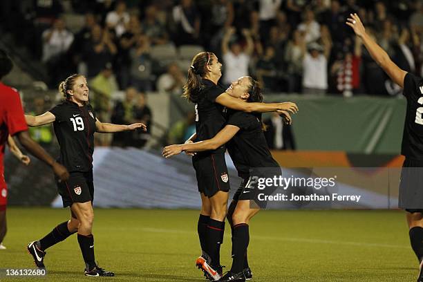 Alex Morgan of the United States is hoisted by Lauren Cheney after scoing a goal against Canada on September 22, 2011 at Jeld-Wen Field in Portland,...