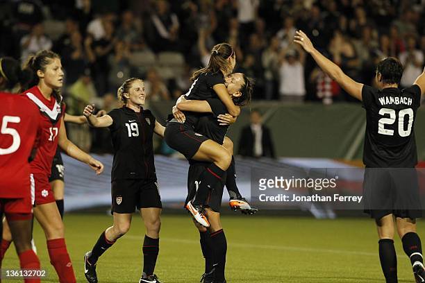 Alex Morgan of the United States is hoisted by Lauren Cheney after scoing a goal against Canada on September 22, 2011 at Jeld-Wen Field in Portland,...