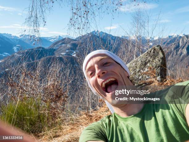 happy young man takes selfie outdoors on a sunny day - funny selfie stockfoto's en -beelden