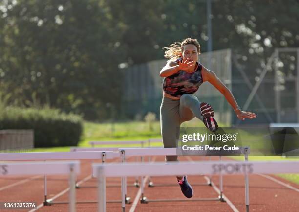 young woman hurdling on running track - concentration camp photos photos et images de collection