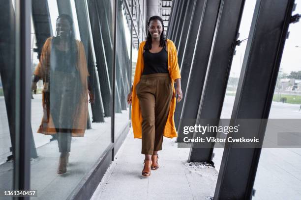 portrait of a black business woman walking near the office building - person walking towards camera stock pictures, royalty-free photos & images