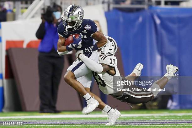 Jamaal Bell of the Nevada Wolf Pack is tackled by Quinton Cannon of the Western Michigan Broncos in the first quarter during the Quick Lane Bowl at...