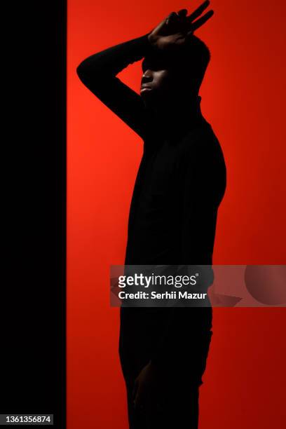 profile photo portrait of handsome man cover his eyes with arm standing in studio - stock photo - hand weight stock-fotos und bilder