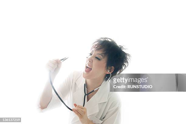 doctor singing with a stethoscope - naughty nurse images stock-fotos und bilder