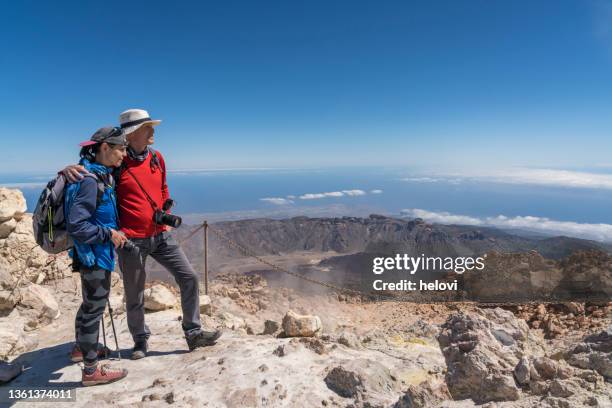 mature couple relaxing on top of mount teide - el teide national park stock pictures, royalty-free photos & images