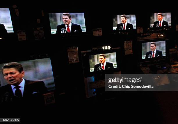 Dozens of televisions display a political advertisement with the image of former President Ronald Reagan at the American furniture electronics and...