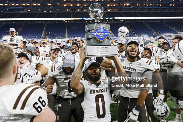 Ra'Sean Davie and the Western Michigan Broncos celebrate with the Quick Lane Bowl trophy after defeating the Nevada Wolf Pack, 52-24 in the Quick...