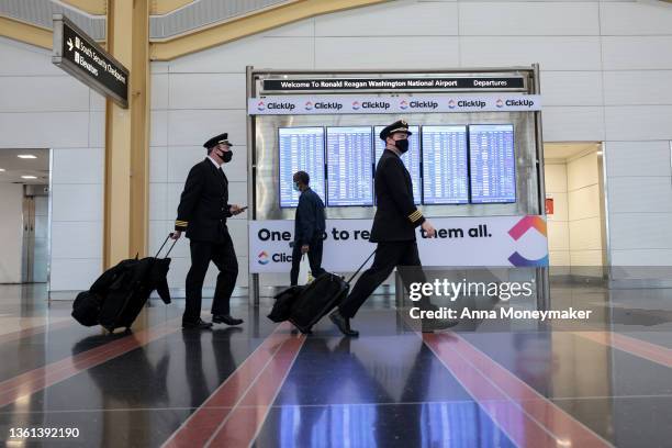 Airline pilots walk through the Ronald Reagan Washington National Airport on December 27, 2021 in Arlington, Virginia. According to media reports, at...